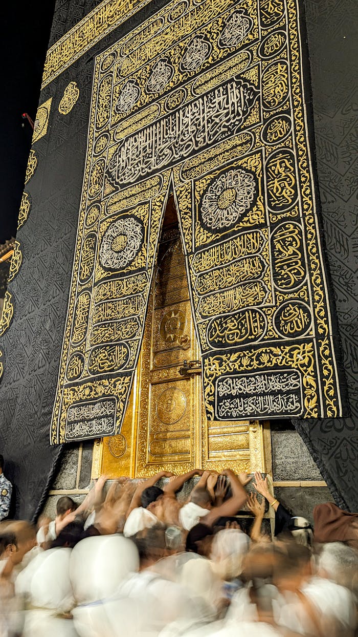 Muslim pilgrims gather in reverence at the Kaaba's golden door in Mecca, Saudi Arabia.